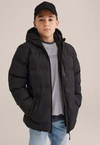 Juodas paminkštintas žiemos paltas su gobtuvu, priekinėmis užtrauktukėmis ir šoninėmis kišenėmis. Dėvimas ant pilkos marškinėlių ir derinamas su šviesiai mėlynomis džinsinėmis kelnėmis.