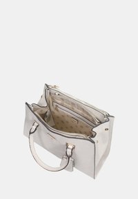 Borsa a mano strutturata bianca realizzata in materiale embossato, dotata di manici doppi, scomparti con zip e un interno beige con fodera a motivi.