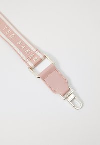 Cinturino in tessuto rosa con strisce bianche, decorato con il logo "TED BAKER" in rilievo. Estremità in pelle con hardware in argento per una chiusura sicura.