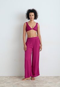 Magenta co-ord set featuring a textured crop top with a V-neck and wide-leg pants with an elastic waistband, made from a soft fabric.