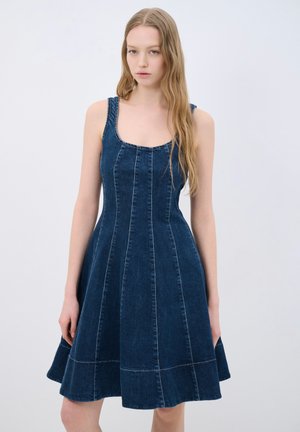 Abito in denim blu scuro con bodice aderente, scollatura quadrata e gonna svasata. Presenta cuciture verticali e una silhouette strutturata.