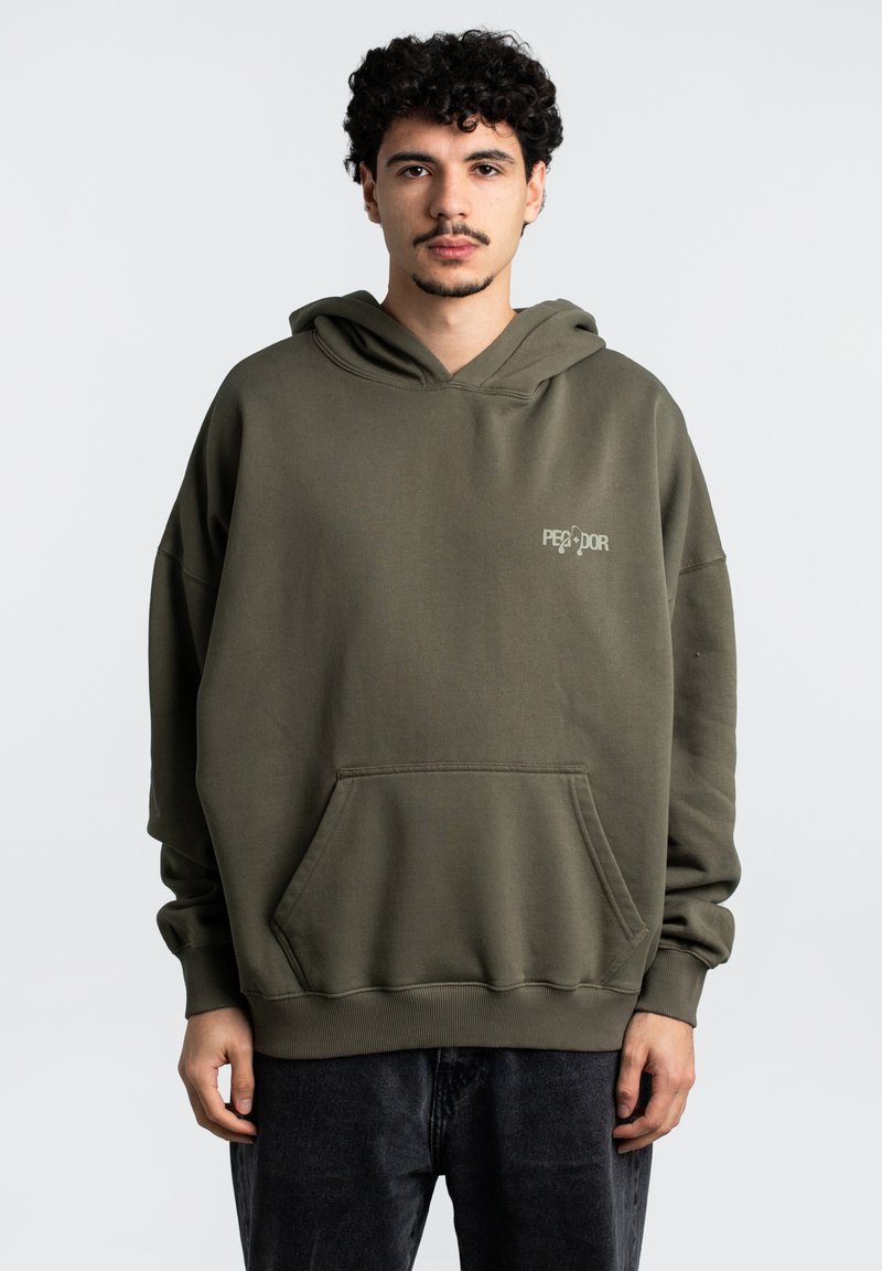 Hoodie verde oliva con tasca frontale, vestibilità ampia e polsini a coste. Presenta un piccolo logo sulla zona sinistra del petto. Tessuto morbido al tatto.