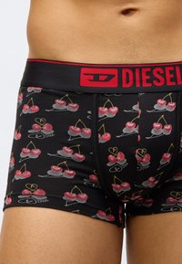 Fekete boxeralsó cseresznyemintával, piros rugalmas derékpánttal, amelyen a "DIESEL" logó látható. Puha anyagból, testre szabott kialakítással.