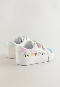 White sneakers with glittery accents, featuring cartoon characters and flowers. Closure with Velcro straps and a textured rubber sole.
