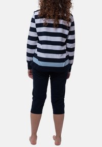 Raidallinen pitkähihainen paita tummansinisessä, valkoisessa ja vaaleansinisessä, yhdistettynä tummansinisiin capri-housuihin. Puuvillakangasta, löysä istuvuus ja rento muotoilu.