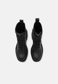 Black leather ankle boots with laces, side zipper, and a smooth finish. Features a rounded toe and sturdy sole.
