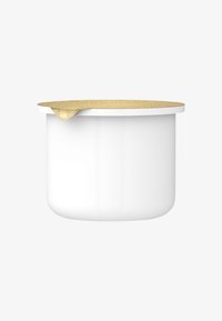 Contenitore in ceramica con corpo bianco lucido e coperchio dorato texturizzato, con una goccia di liquido sul bordo.