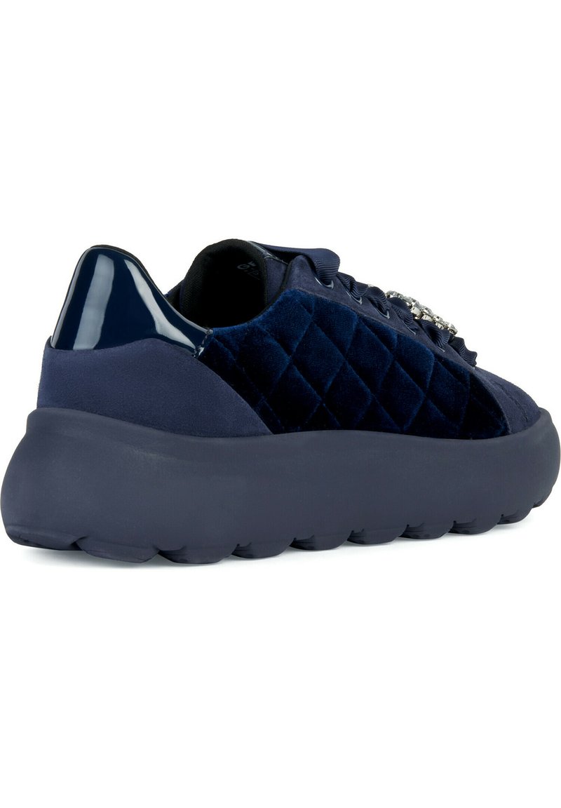 Sneaker in velluto blu navy con motivo trapuntato, tacco in plastica lucida e suola in gomma spessa. Presenta lacci decorativi.