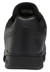 Vue arrière d'une basket en cuir noir pour homme avec semelle texturée et col rembourré, étiquette de taille visible à l'intérieur de la chaussure.