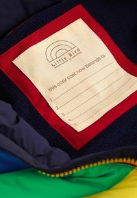 Bunda s fleecovou podšívkou s námorníkovým exteriérom, červenou nášivkou a smetanovou menovkou na personalizáciu, obsahujúca päť prázdnych riadkov na mená.