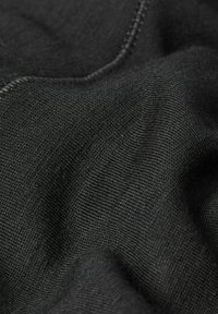 Tissu noir texturé avec une apparence douce et tissée, présentant des détails subtils de couture et un tombé lisse. Convient pour les vêtements ou la tapisserie.