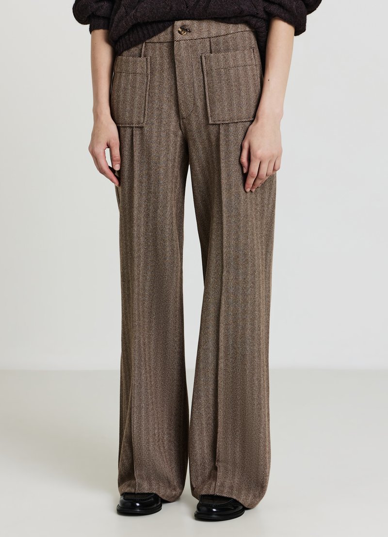 Hose mit weitem Bein in braunem Fischgrätmuster, mit Vordertaschen und Knopfverschluss. Der Stoff wirkt weich und hat eine glatte Textur.