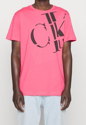 Lyserød bomuld T-shirt med stort sort tekstdesign på forsiden, korte ærmer og klassisk rund hals.