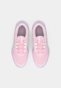 Une paire de chaussures de course Nike roses avec des accents et des lacets blancs, vue de dessus sur un fond gris clair.