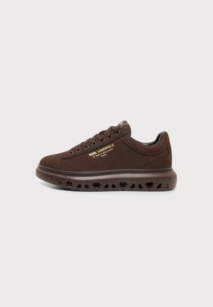 Mørkebrun sneaker med snørelukning foran og tyk perforeret sål, med guld Karl Lagerfeld-logo og Paris-adresse på siden.