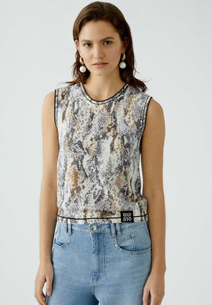 Mouwloos topje in slangenprint met een kleurenpalet van wit, grijs en bruin. Voorzien van een geribbelde halslijn en zwarte afwerking aan de onderrand.