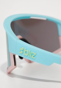 Sportsonnenbrille mit einem hellblauen Rahmen, pinken Akzenten, grauen Gläsern und einem "bliz"-Logo an der Seite. Aus flexiblem Kunststoff gefertigt.