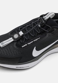 Le scarpe Nike Pegasus presentano una tomaia in mesh nera, dettagli riflettenti, una suola in gomma e un logo swoosh bianco stilizzato. Sono leggere e con una vestibilità aderente.