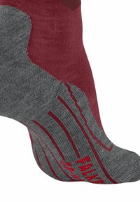 Calza bordeaux e grigia con disegno strutturato, dettagli rossi e motivi a strisce sulla sezione grigia. Materiale morbido e lavorato a maglia.