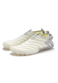 Leichte, cremefarbene Slipper mit einem gesteppten Textil, grauen Akzenten und einer flexiblen, durchsichtigen Sohle mit abgerundeten Zehen.