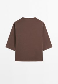 T-shirt marron à manches courtes avec col rond et ourlet droit, présenté à plat, dos vers le haut, sur fond blanc.