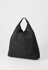 Black suede oversized tote bag with a single handle and wide opening, displayed against a plain light background.