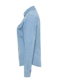 Camicia di jeans azzurro chiaro a maniche lunghe con una singola tasca sul petto e polsini con bottoni, mostrata dal lato sinistro su sfondo bianco.