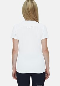 Vit kortärmad skjorta tillverkad av andningsbart tyg, med rundad krage, bakre logotyp och en slim fit-design. Detaljer inkluderar reflexinslag.