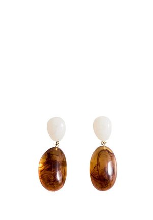 Clous d’oreilles ovales blancs avec de grands pendentifs ovales en goutte, brillants et marron marbré, suspendus sous chaque clou.