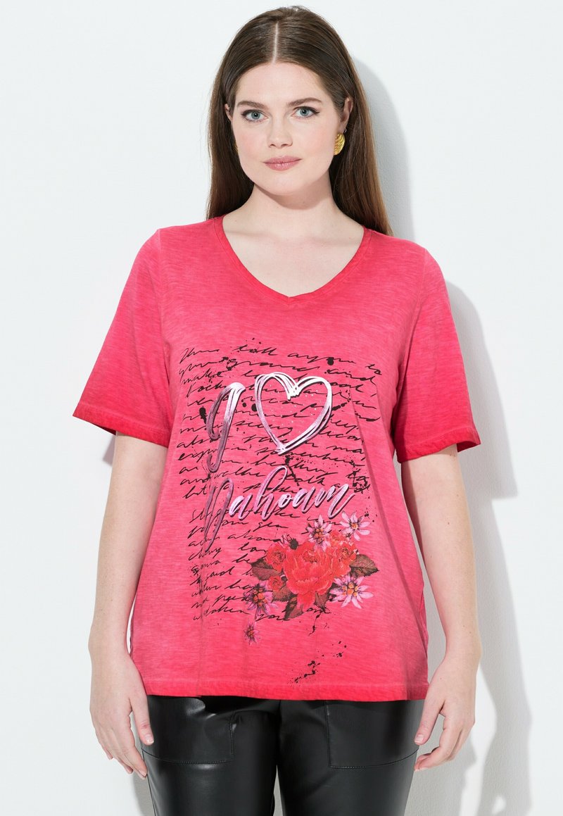 Camiseta de cuello en V rosa con mangas cortas, que presenta un gráfico floral, texto "Te amo [nombre]" y un diseño de patrón escrito. Textura suave.