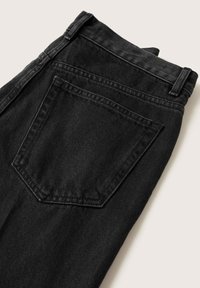 Jeans di denim neri piegati, mostrano la tasca posteriore e i passanti per cintura su uno sfondo chiaro.