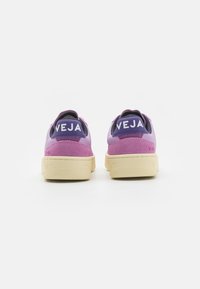 Sneaker in pelle viola e rosa con suola in gomma crema; presenta il logo "VEJA" sul tallone; progettato con una finitura liscia e testurizzata.