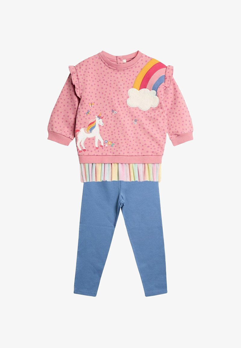 Roza pulover s dizajnom samoroga in mavrice, z nabranimi rokavi in pastelno nabrano spodnjim delom, v kombinaciji z modrimi legicami. Iz bombažnega materiala.