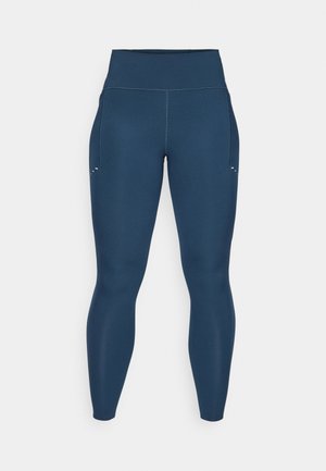 Leggings azul-marinho feitos de material elástico, com uma cintura alta, bolsos laterais e detalhes subtis perto dos bolsos.