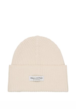 Bonnet tricoté crème avec bordure repliée, comportant une étiquette cousue avec la marque. La texture est côtelée, offrant un aspect doux.