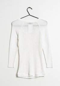 Maglione bianco a maniche lunghe su una gruccia, con un motivo testurizzato e scollo a barco, con polsini e orlo a coste.