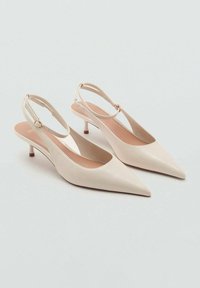 Bež usnjeni slingback čevlji s koničastimi prsti, tankim trakom in nizko stiletto peto. Gladka tekstura in minimalni oblikovni detajli.