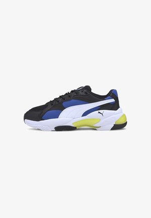 Baskets de sport Puma noires, bleues, blanches et jaunes avec un design à lacets et logo sur le côté, présentées sur fond blanc.