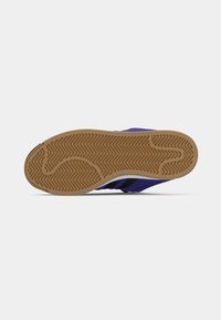 Μονοκόματο μοβ πέλμα παπουτσιού με διακοσμητικό μοτίβο ψαροκόκαλο, διαθέτοντας ελαστική υφή και ανοιχτό καφέ λεπτομέρεια, που αναδεικνύει έναν κομψό σχεδιασμό.