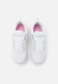 Baskets de sport blanches en matériau mesh, de forme arrondie, avec des accents texturés et des semelles intérieures et lacets roses. Logo de la marque visible sur le dessus.