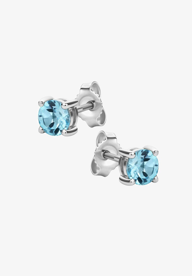 Krožne uhane iz srebrnatega kovinskega materiala, ki vsebujejo svetlo modre dragulje, pritrjene s štirimi zobci in zapiranjem za metuljčke.