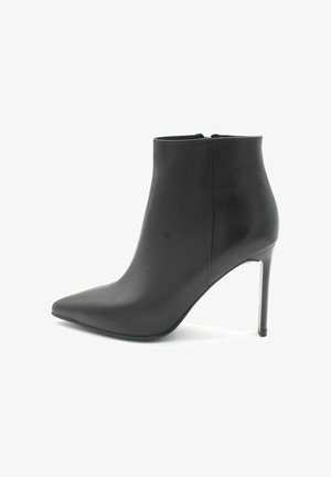 Bottillon en cuir noir avec un bout pointu, un talon aiguille mince et une texture lisse. Dispose d'une fermeture éclair à l'arrière.