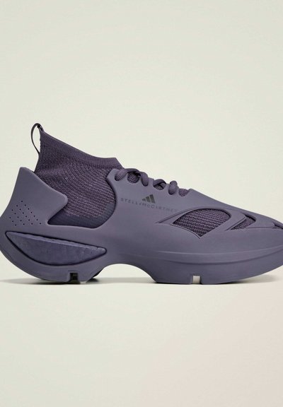Purple athletic shoe with a knitted upper and molded rubber sole. Features reinforced accents, textured material, and a sock-like collar.