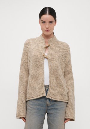 Beige knitted cardigan with ribbed texture, high collar, and wooden toggle closures. Features wide sleeves and a relaxed fit design.
