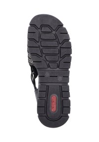 Semelle de chaussure en caoutchouc noir avec un motif de grip texturé, comportant un logo de marque en rouge. Design découpé pour la ventilation et construction légère.
