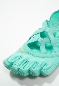 Vattensko med en livlig turkos tygöverdelsdesign, femtåform, texturerad sula och elastiska remmar för en säker passform.