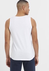 Weißes Baumwoll-Tanktop mit rundem Ausschnitt und breiten Trägern, das eine glatte Textur und eine lockere Passform bietet.