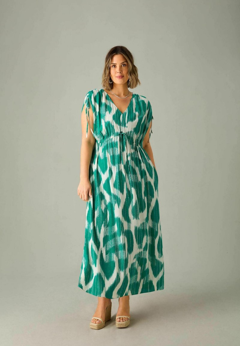 Robe maxi en vert et blanc avec un motif abstrait, fabriquée en tissu léger, présentant un décolleté en V, des bretelles réglables et une coupe décontractée.