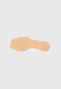 Semelle tan avec grip texturé, dotée d'une sangle tissée colorée au niveau des orteils. Finition lisse sur le pied.