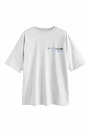 Light gray oversized t-shirt made of cotton, featuring a round neckline and short sleeves. Text on front reads "THE ART OF MOVEMENT."